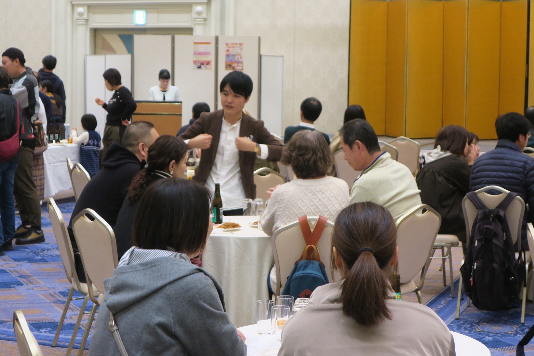 企業イベントやパーティーでテーブルを囲む観客にメンタリズムの出張エンターテイメントを披露するKoki Hori